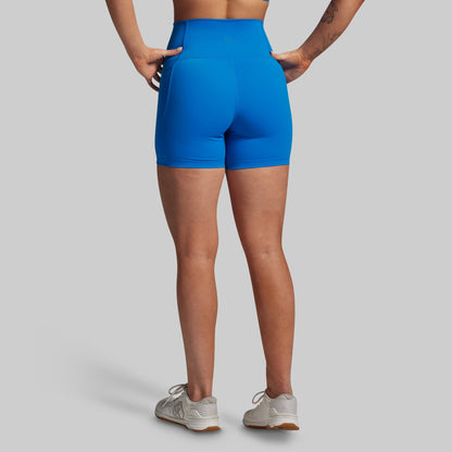 Person wearing blue athletic shorts on a gray background