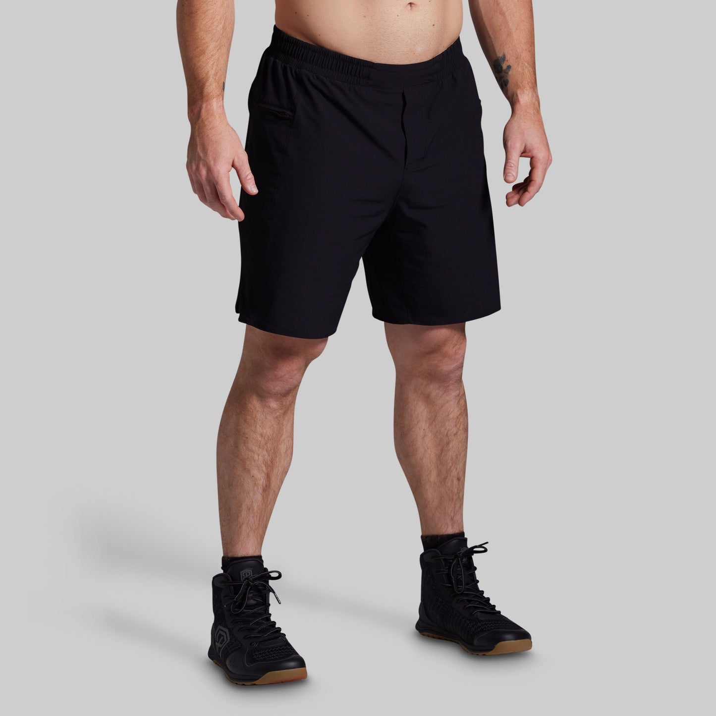 Person wearing black shorts on a gray background