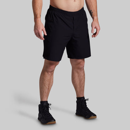 Person wearing black shorts on a gray background