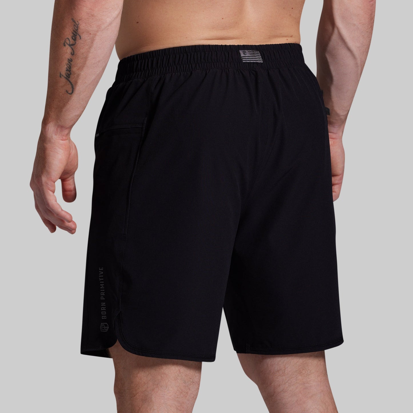 Black shorts worn by a person on a plain background