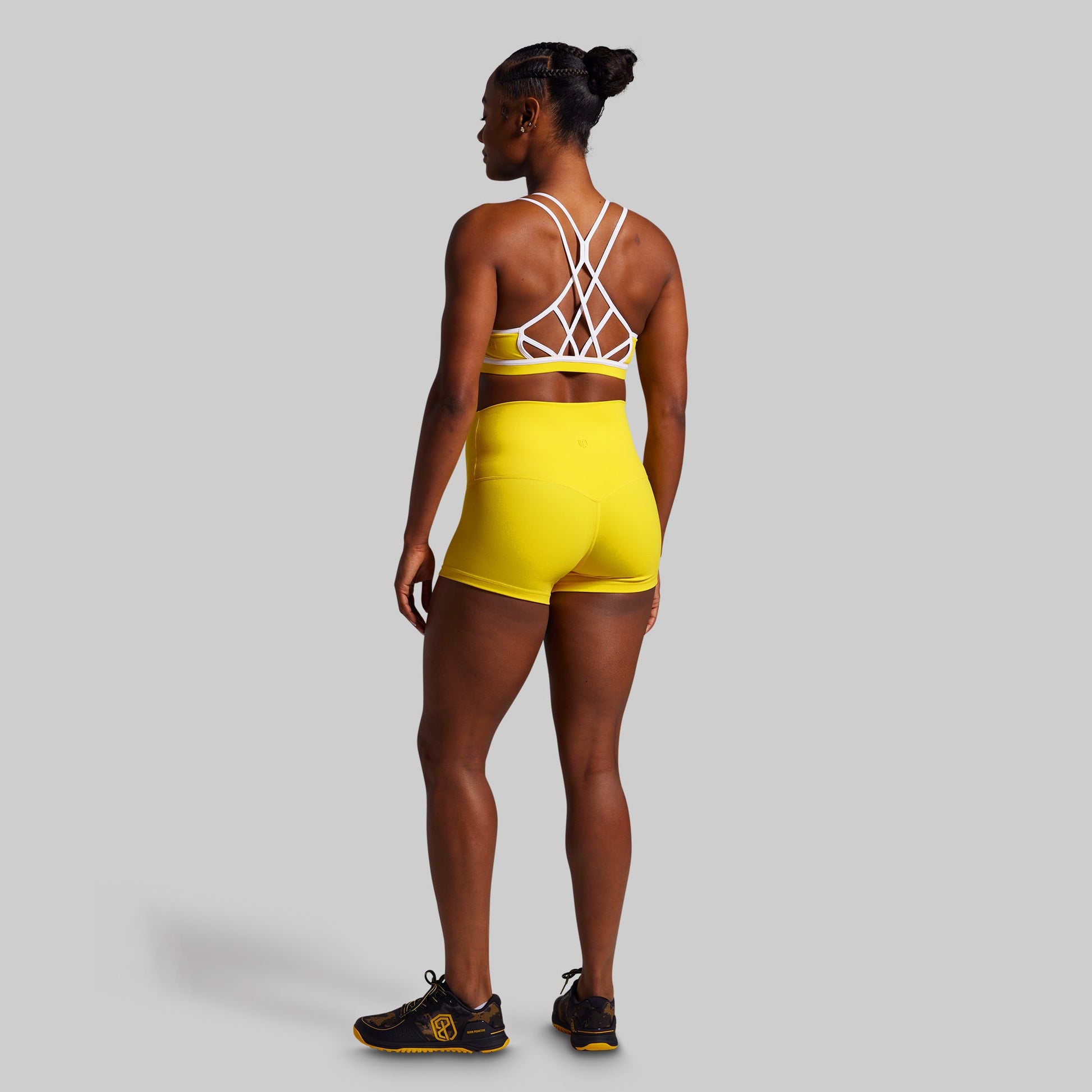 Person wearing a yellow sports outfit with a gray background