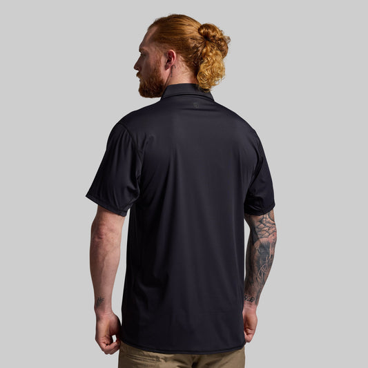 Man wearing a black short-sleeve shirt on a gray background