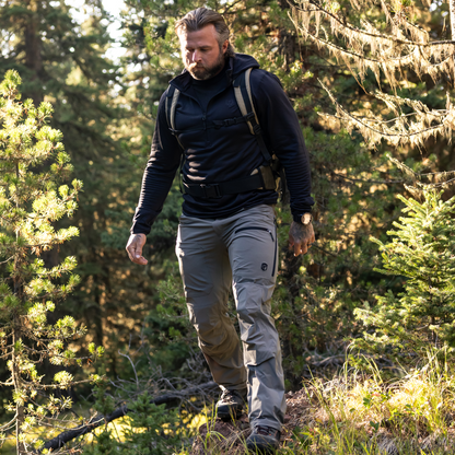 Man hiking through a forest wearing outdoor gear