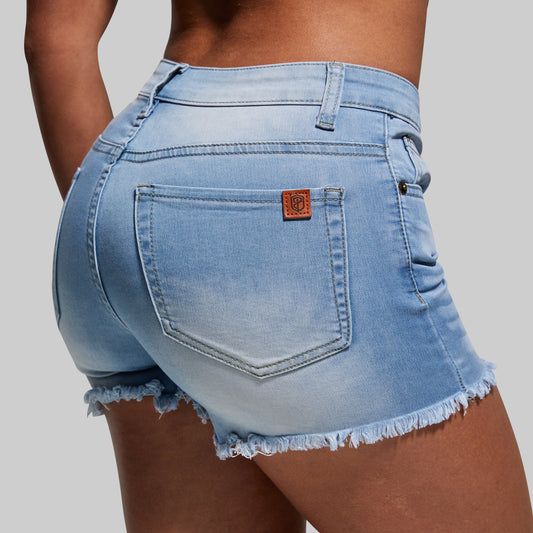 Light blue denim shorts with a brand logo on a gray background