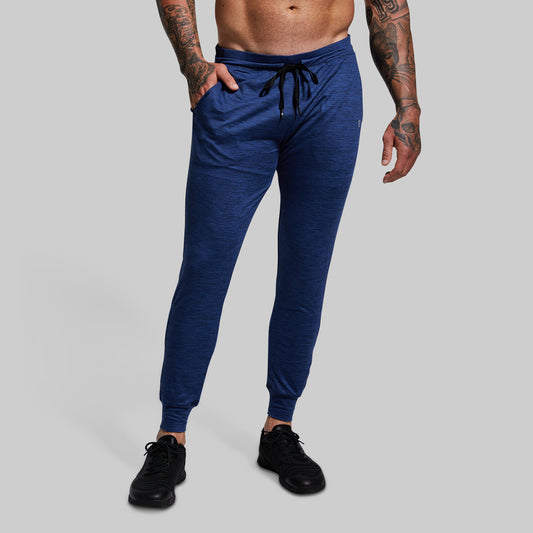 Person wearing blue jogger pants on a gray background