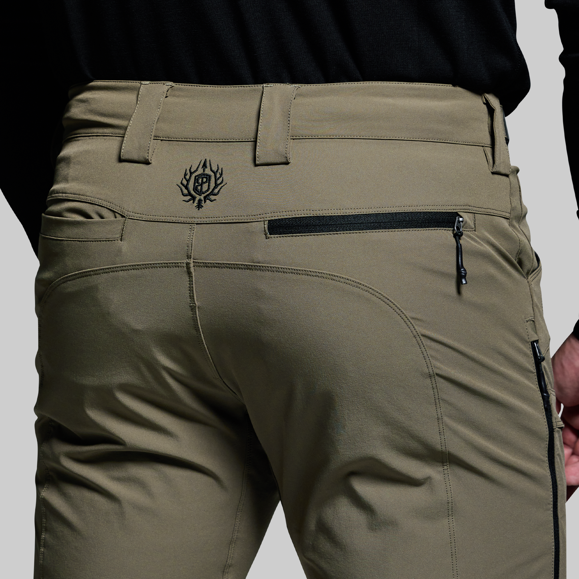 Green pants with a brand logo on a gray background
