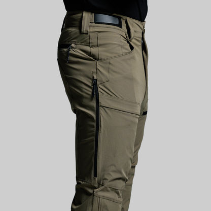Green outdoor pants with zippers and pockets on a gray background