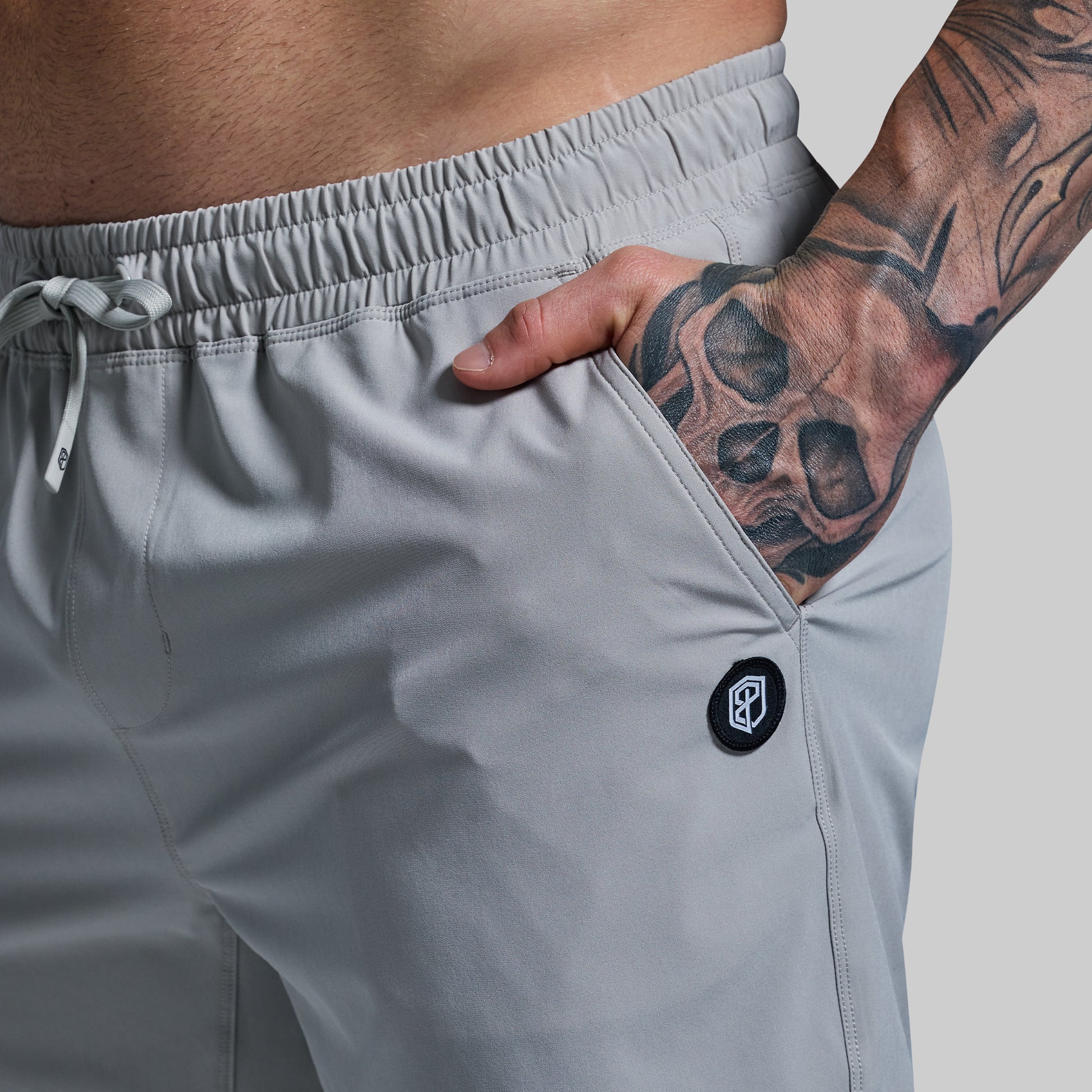 Gray athletic shorts with a brand logo on a neutral background