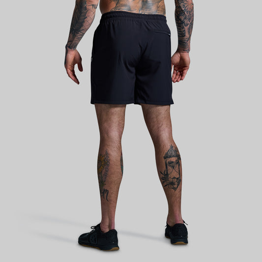 Person wearing black shorts on a plain background