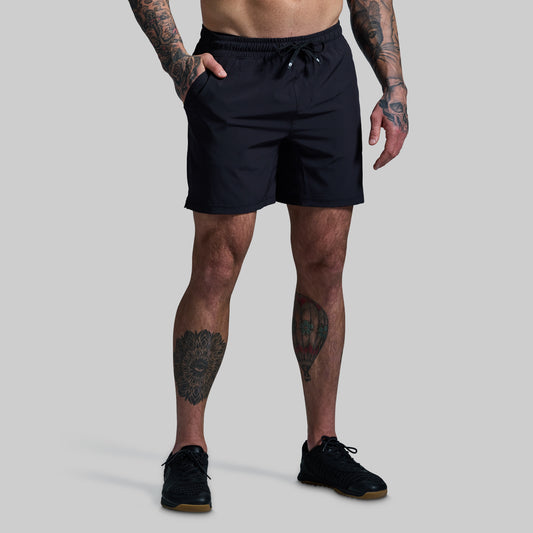 Person wearing black shorts on a gray background