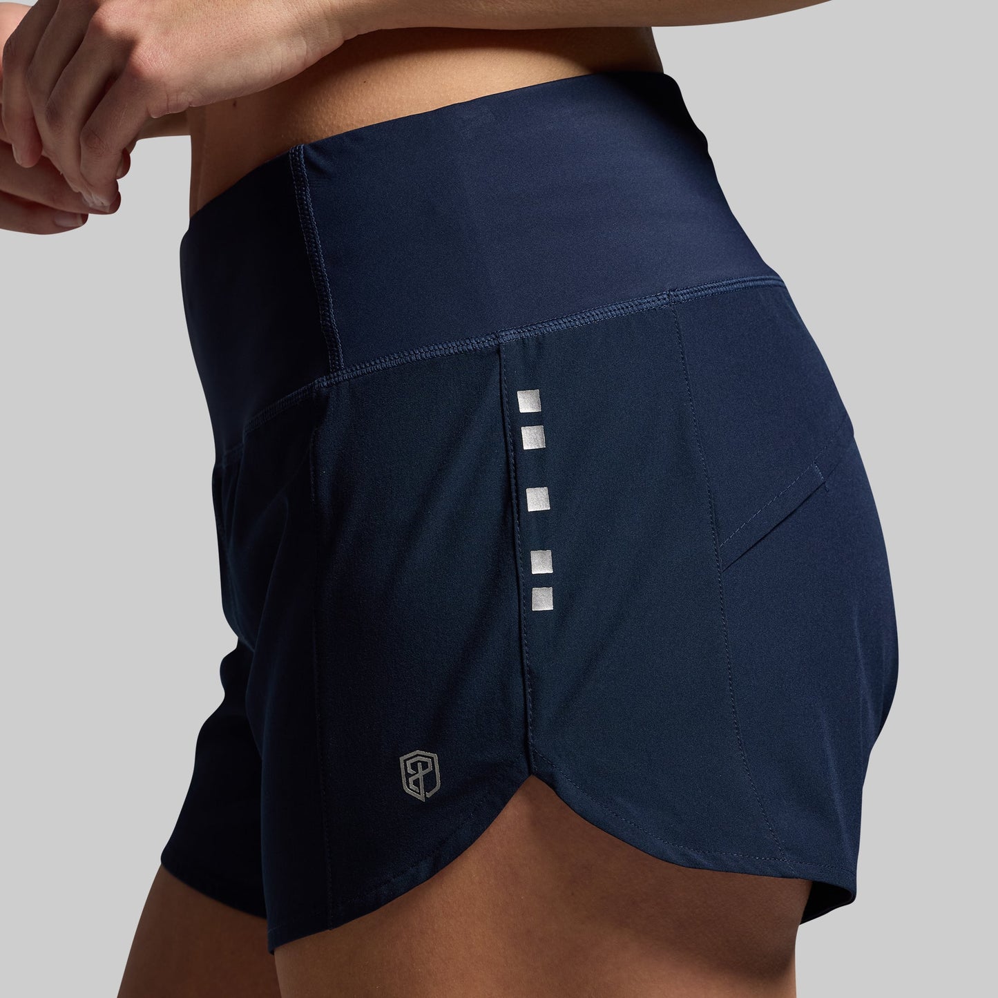 Navy athletic shorts with a brand logo on a gray background