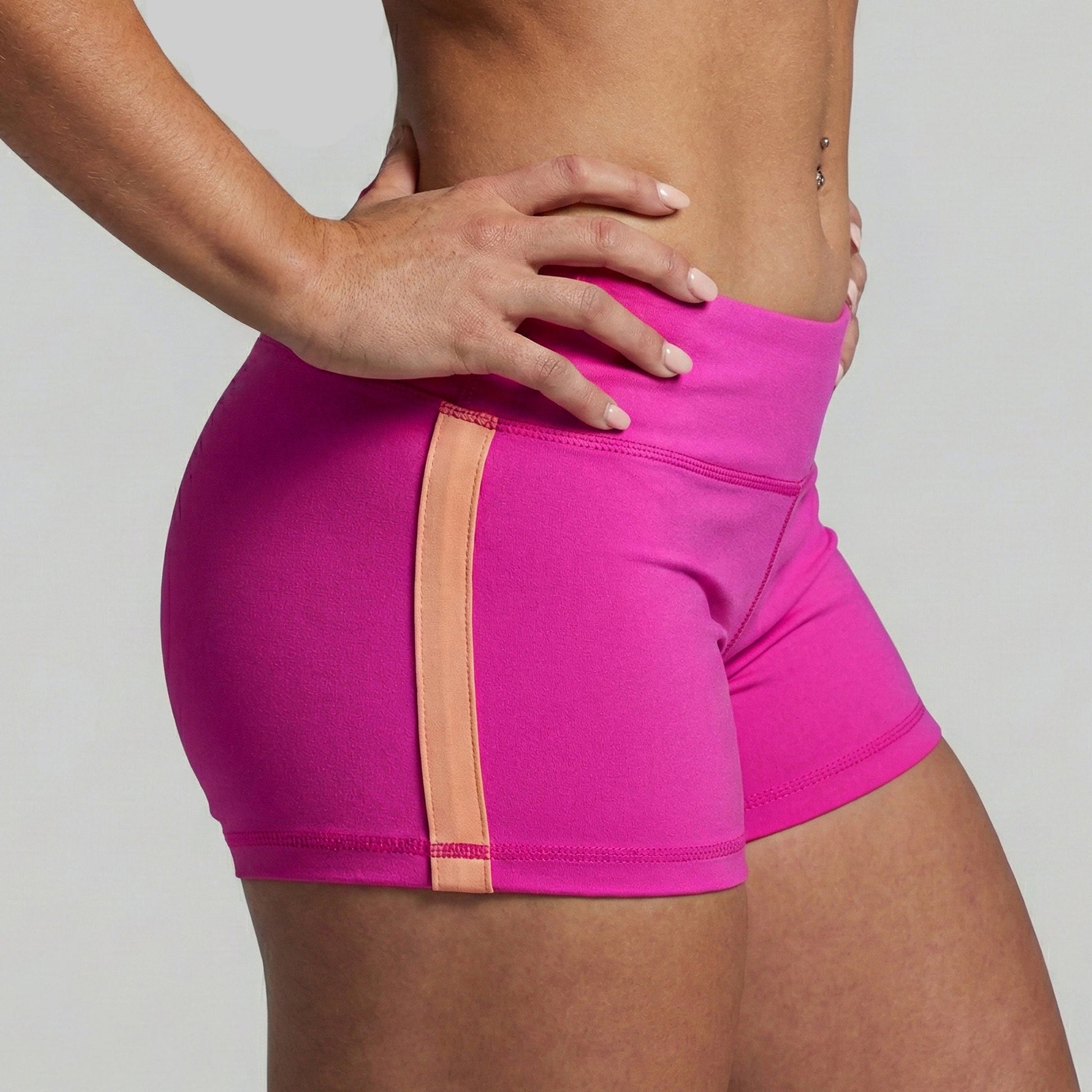 Pink athletic shorts with a peach accent on a gray background