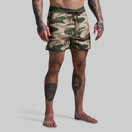 Person wearing camouflage shorts on a plain background