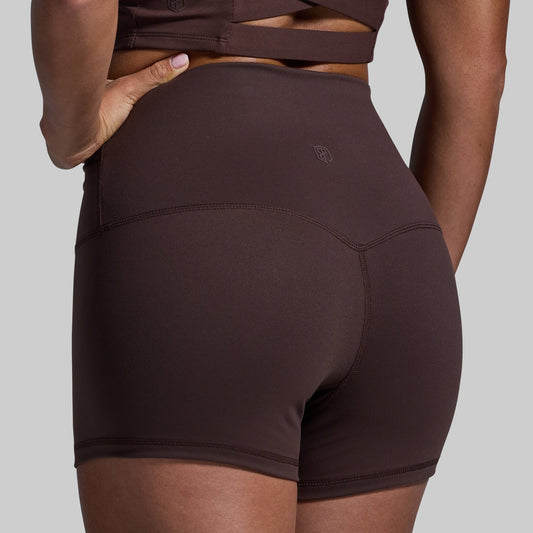 Brown athletic shorts worn by a person on a gray background