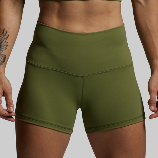 Green athletic shorts worn by a person on a plain background