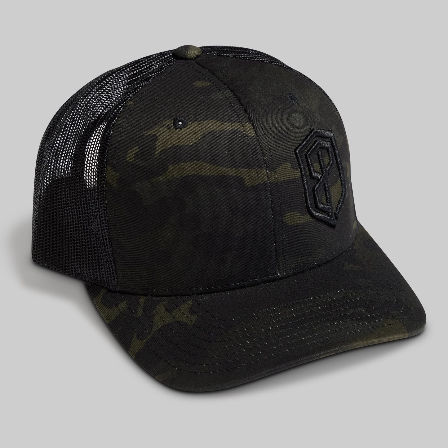 Camouflage trucker hat with a logo on a gray background