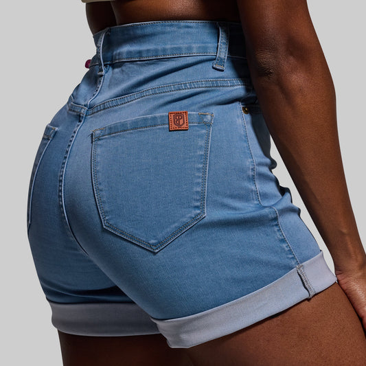 Blue denim shorts with a brand logo on a gray background