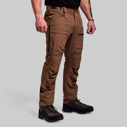 Brown outdoor pants worn by a person on a gray background