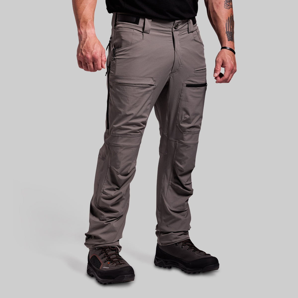 Person wearing gray outdoor pants on a light gray background