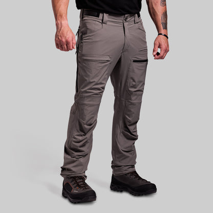 Person wearing gray outdoor pants on a light gray background