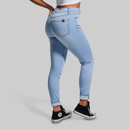 Light blue jeans worn by a person on a gray background