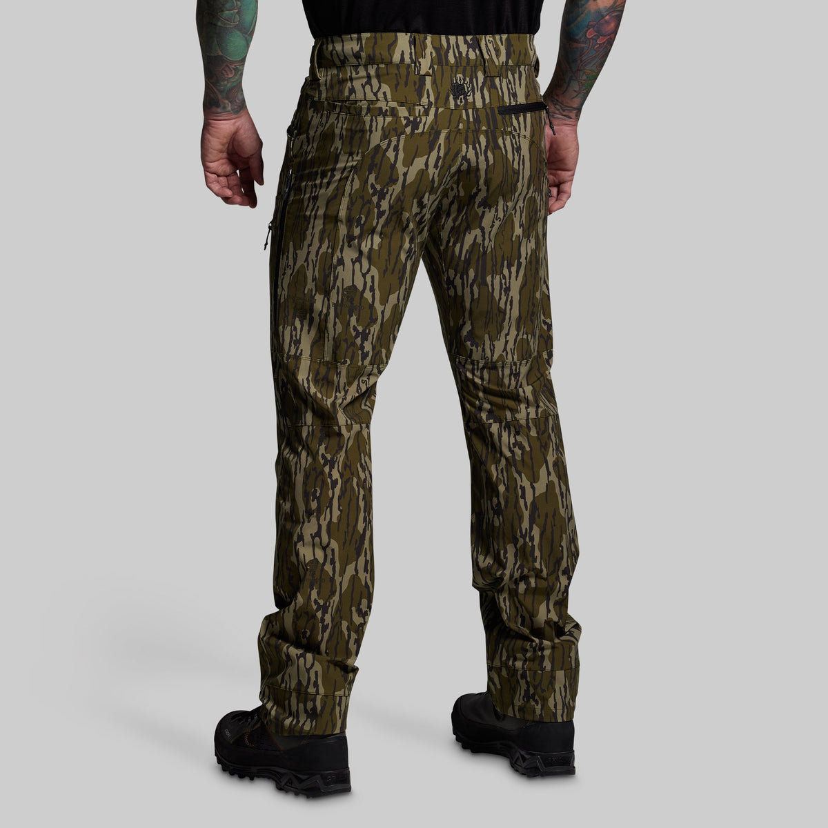 Camouflage pants worn by a person on a gray background