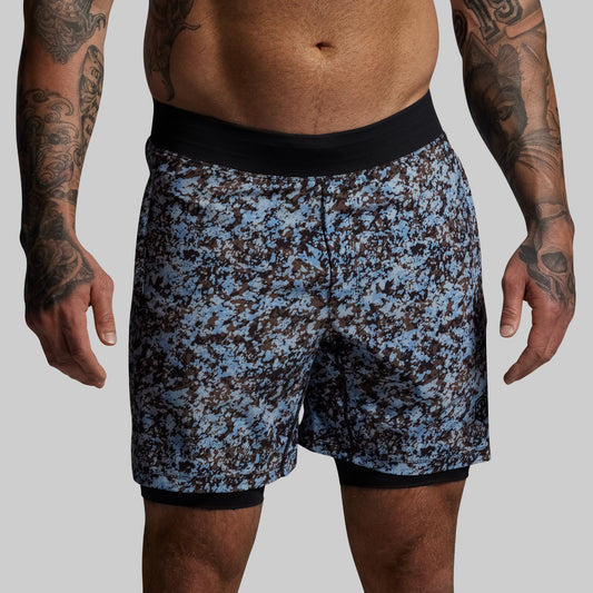 Person wearing blue and black patterned shorts on a gray background