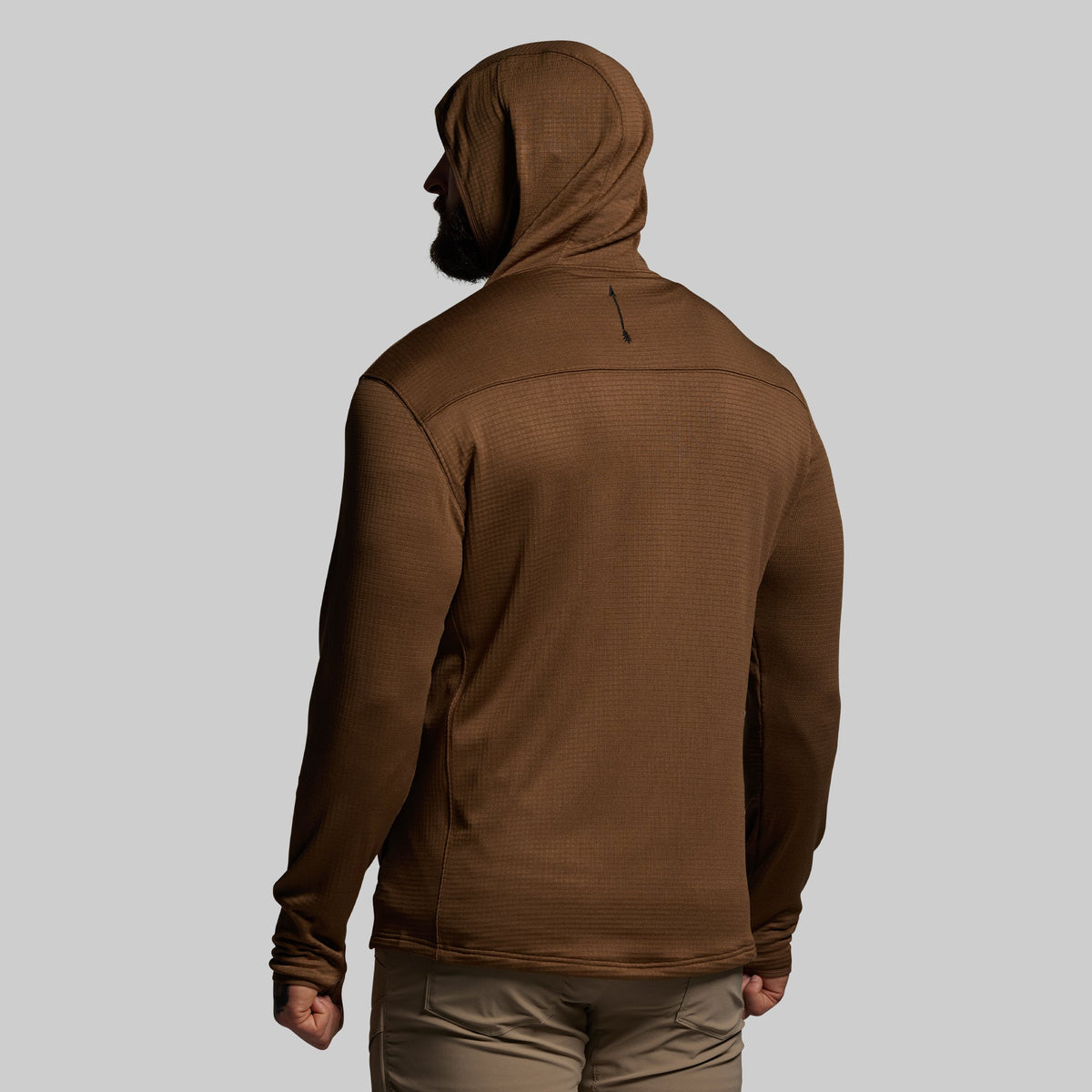 Person wearing a brown hoodie on a gray background