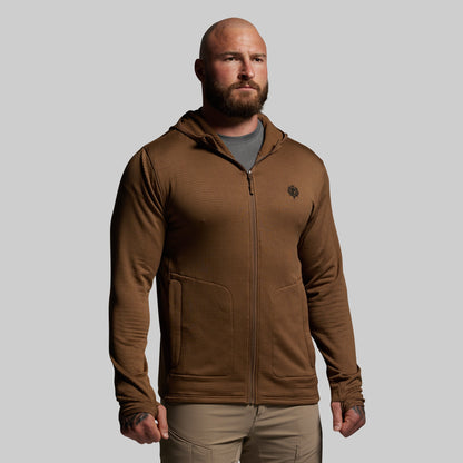 Man wearing a brown hoodie with a logo on a gray background