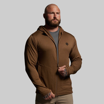 Man wearing a brown hoodie on a gray background