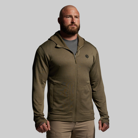 Man wearing a green full zip hoodie with a logo on a gray background