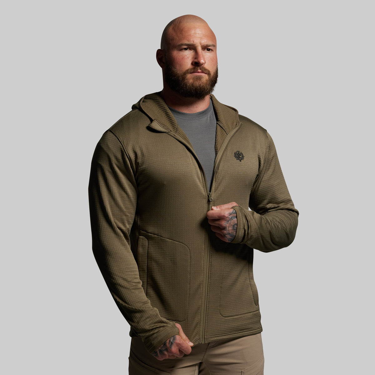 Man wearing a green hoodie on a gray background