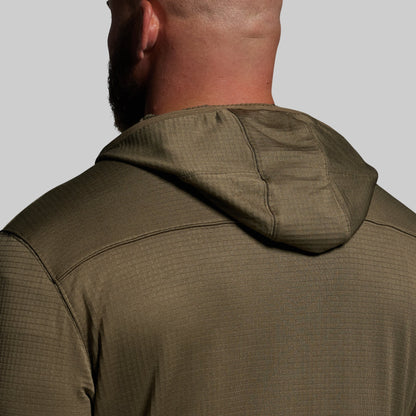 Green hoodie worn by a person on a plain background