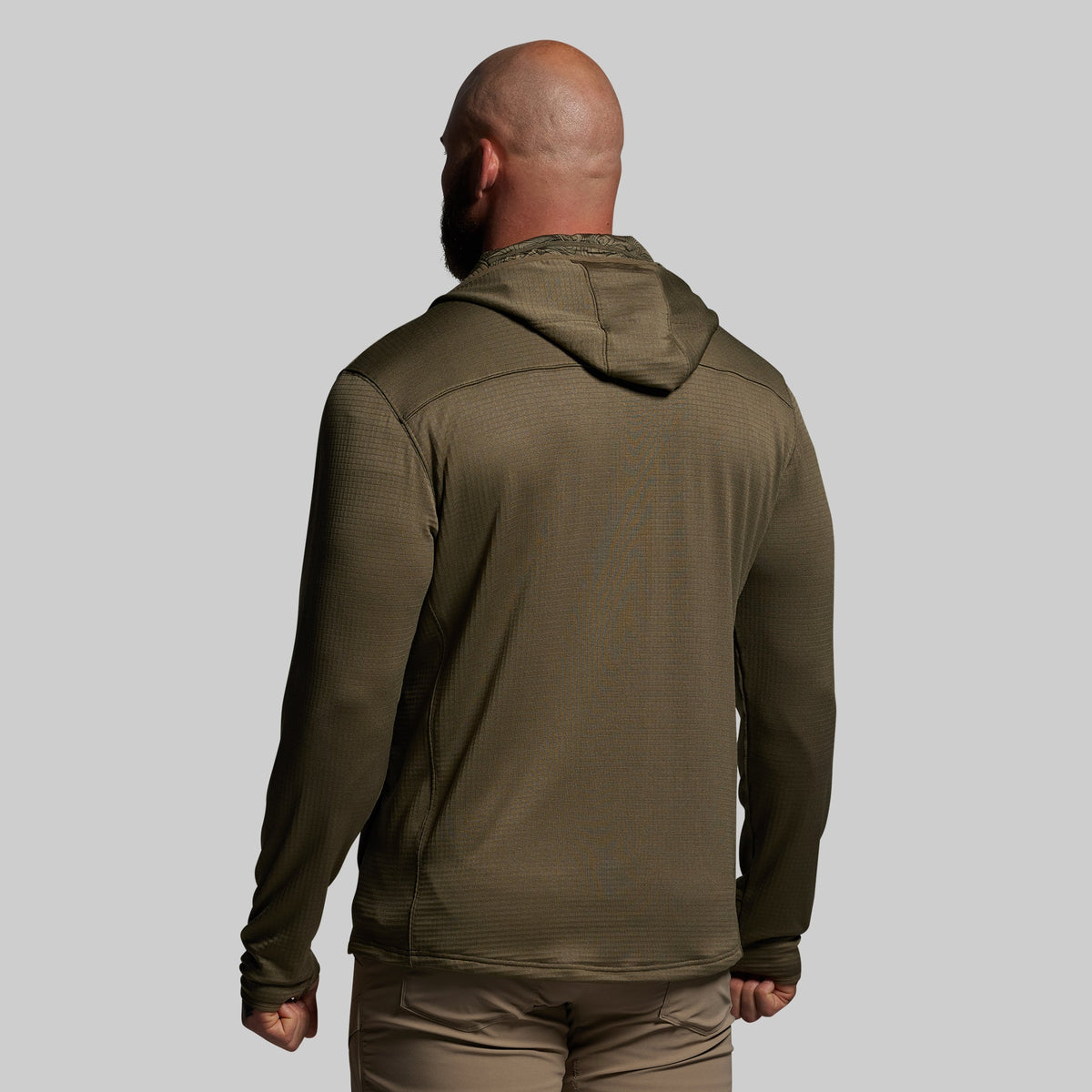 Person wearing a green hoodie on a plain background