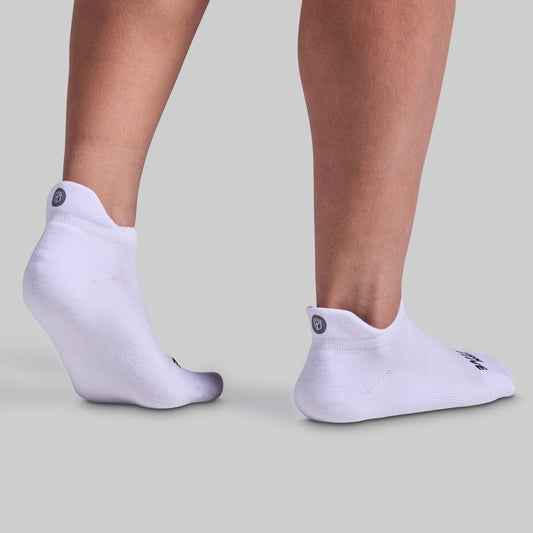 A pair of white performance ankle socks designed for training sessions and everyday wear, featuring cushioned panels and breathable fabric.