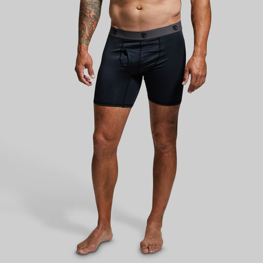 Man wearing black boxer briefs on a gray background