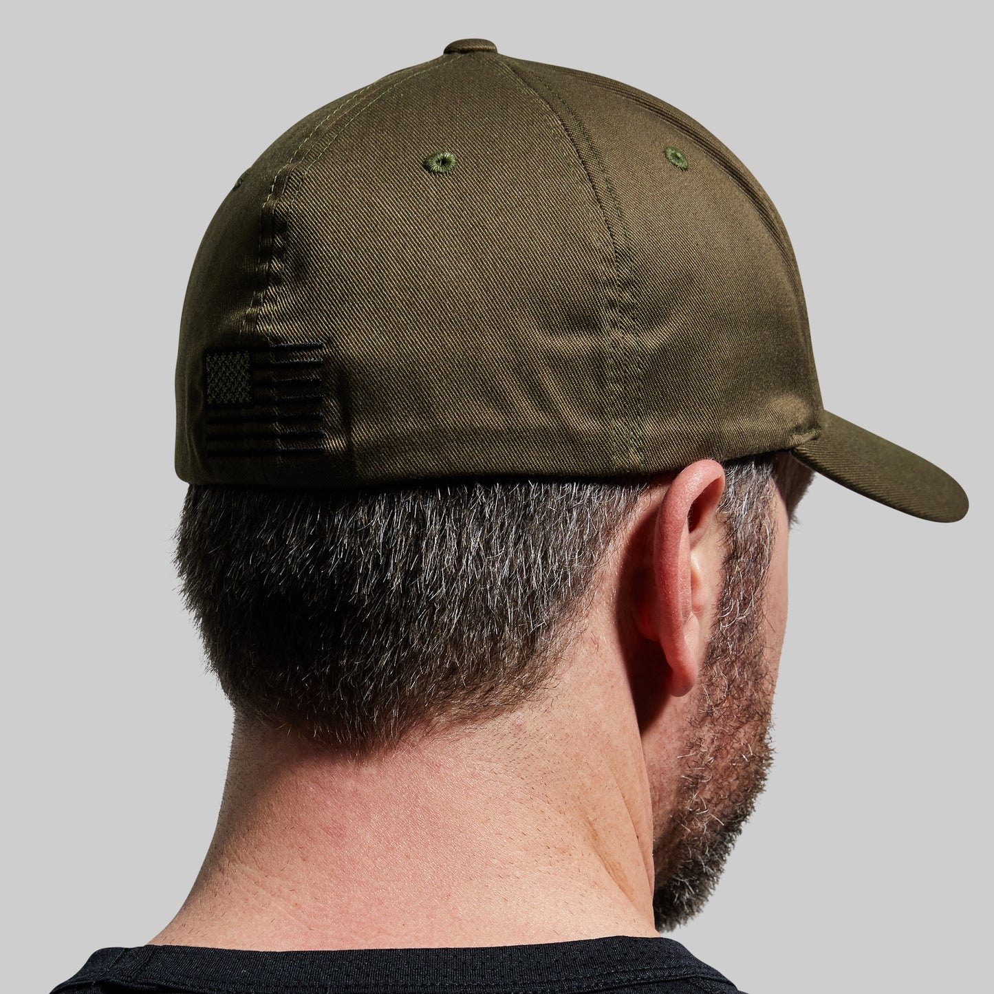 Person wearing a green cap on a gray background