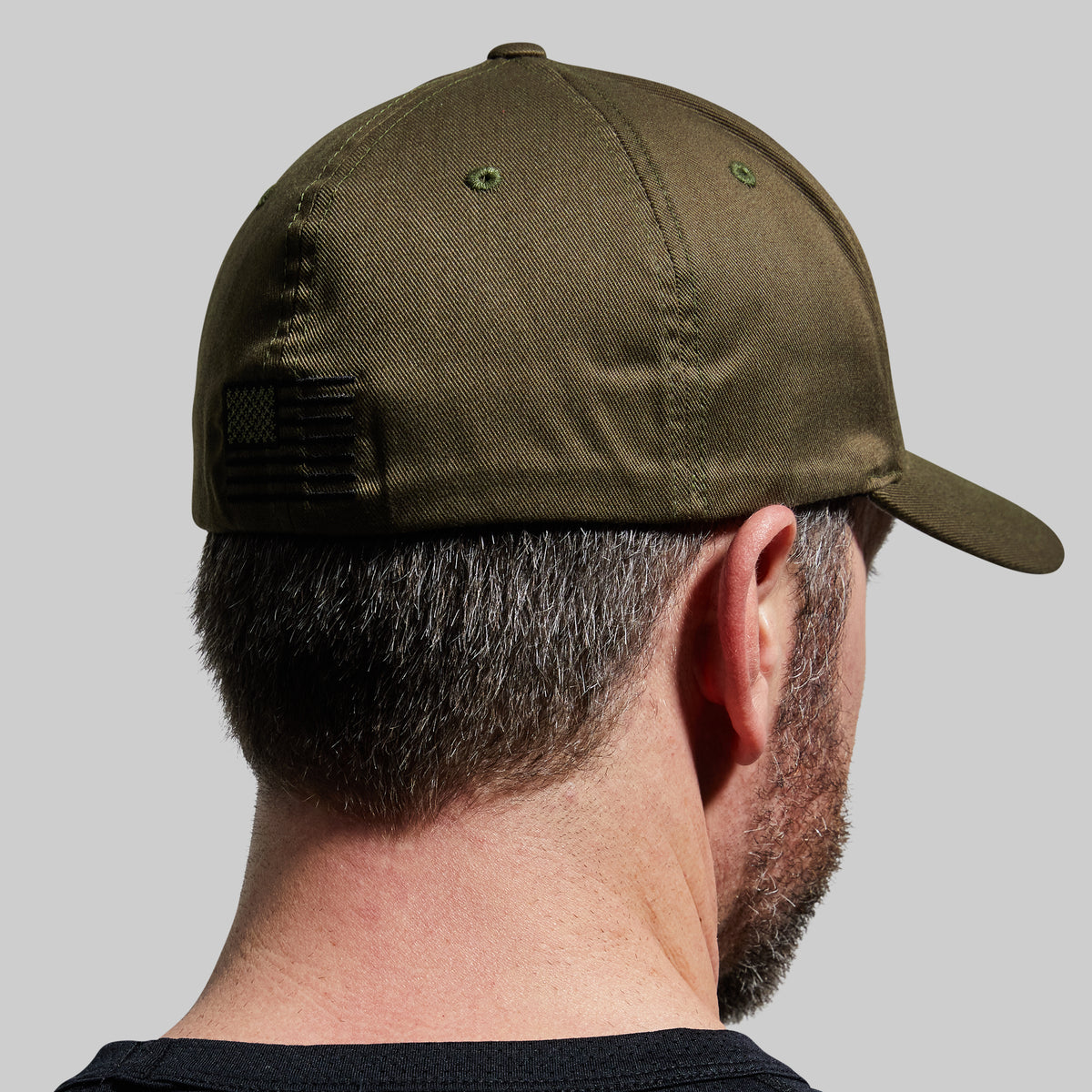 Person wearing a green cap on a gray background