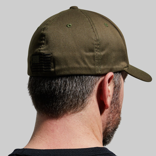Person wearing a green cap on a gray background