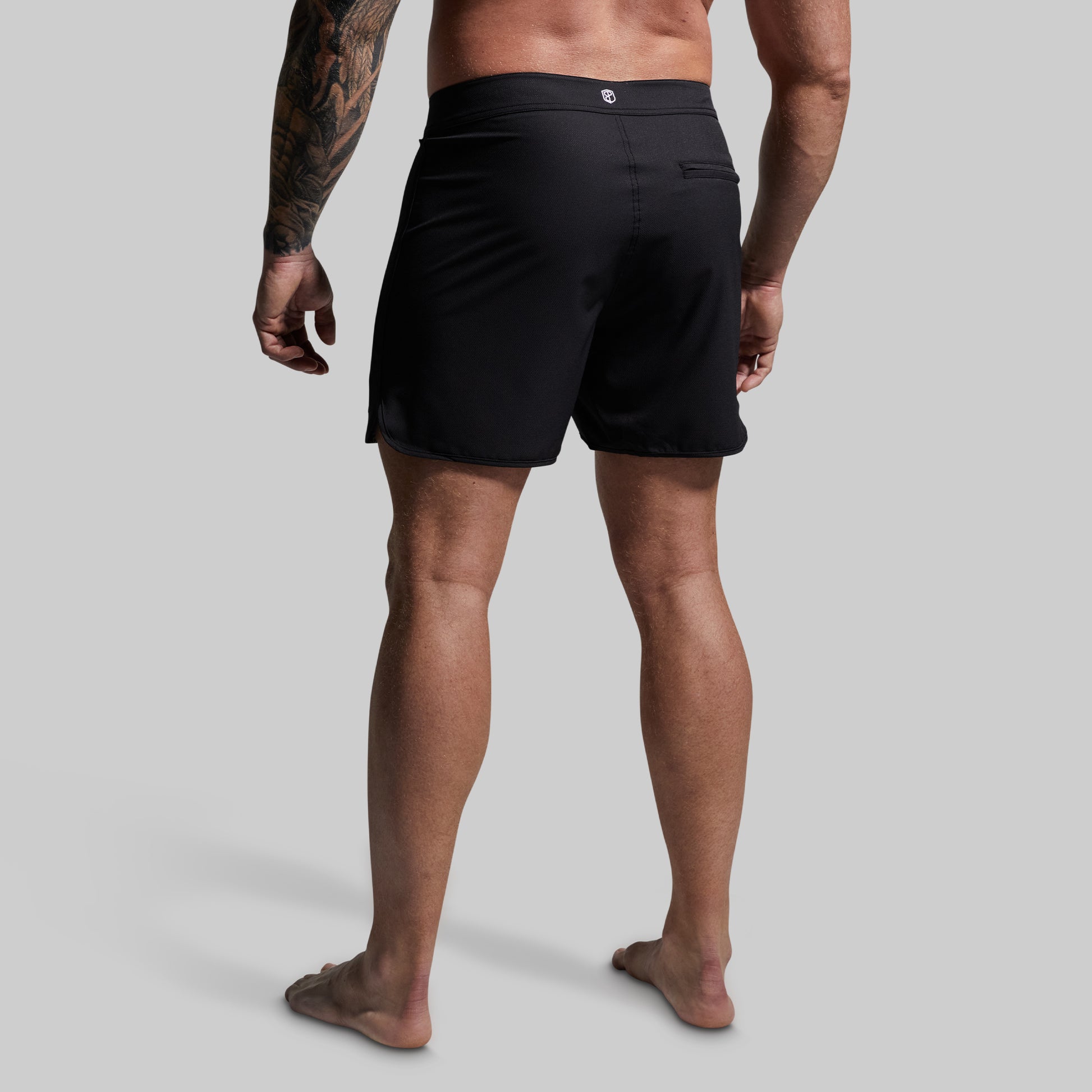 Person wearing black shorts on a plain background