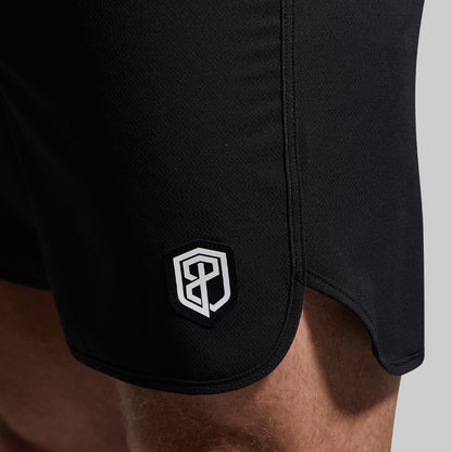Black shorts with a logo on the side against a neutral background