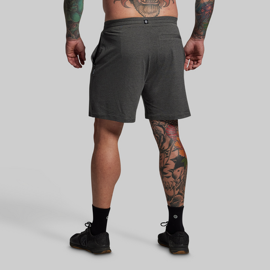 Person wearing gray shorts on a plain background
