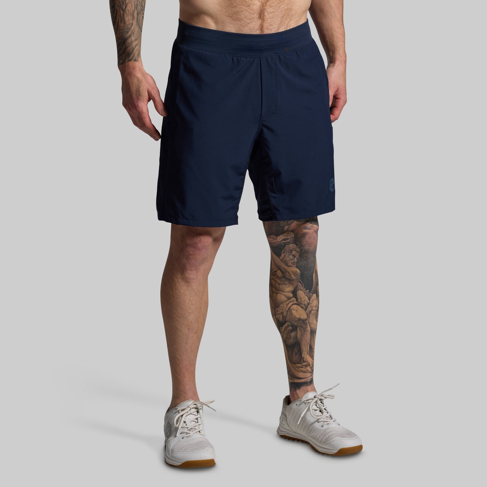 Person wearing navy shorts on a gray background