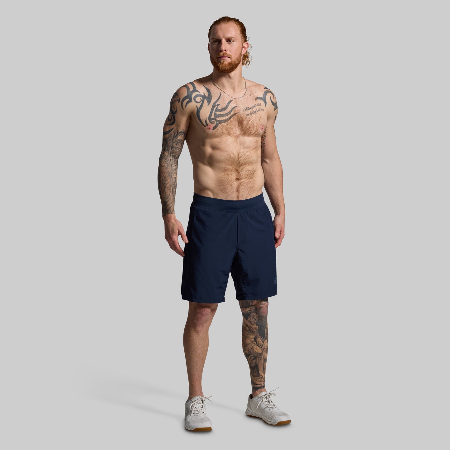 Man wearing navy shorts on a gray background