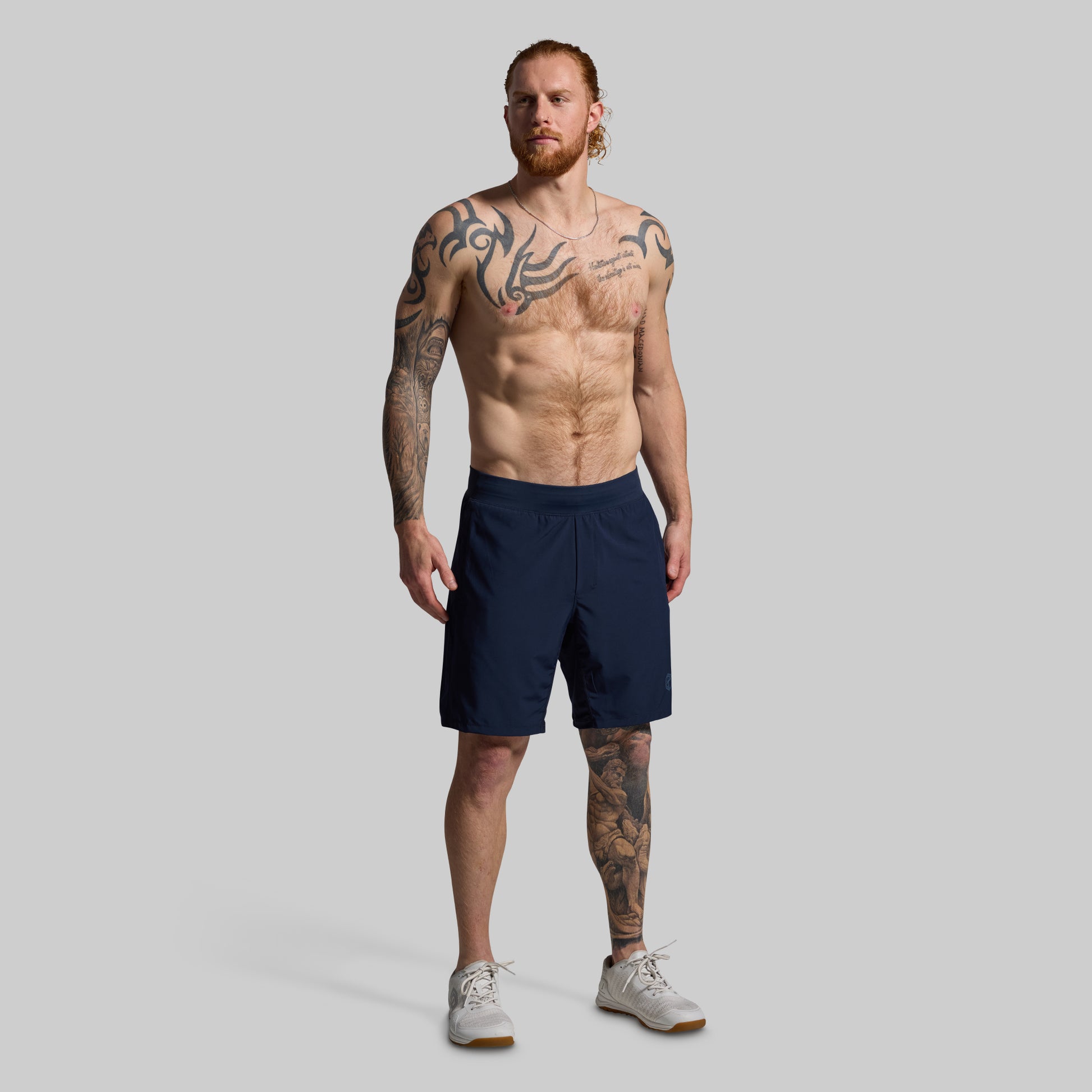 Man wearing navy shorts on a gray background