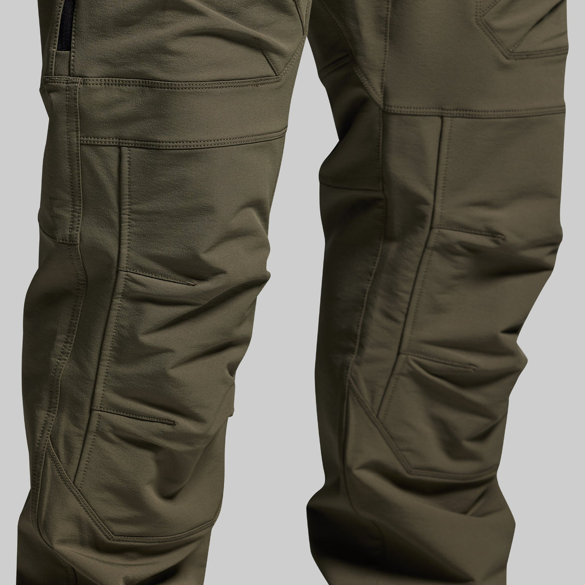 Close-up of olive green outdoor pants on a light gray background