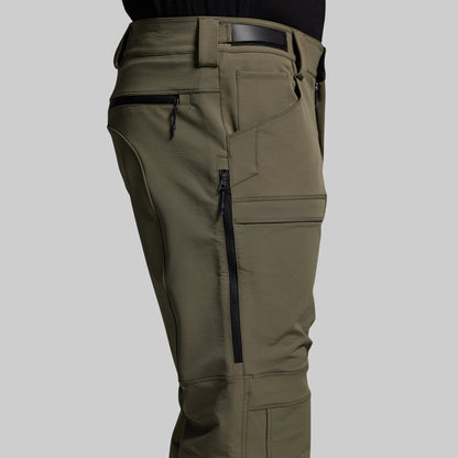 Olive green outdoor pants with zippered pockets on a gray background