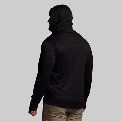 Person wearing a black hoodie from behind on a gray background