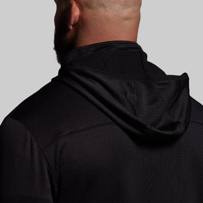 Person wearing a black hoodie on a plain background