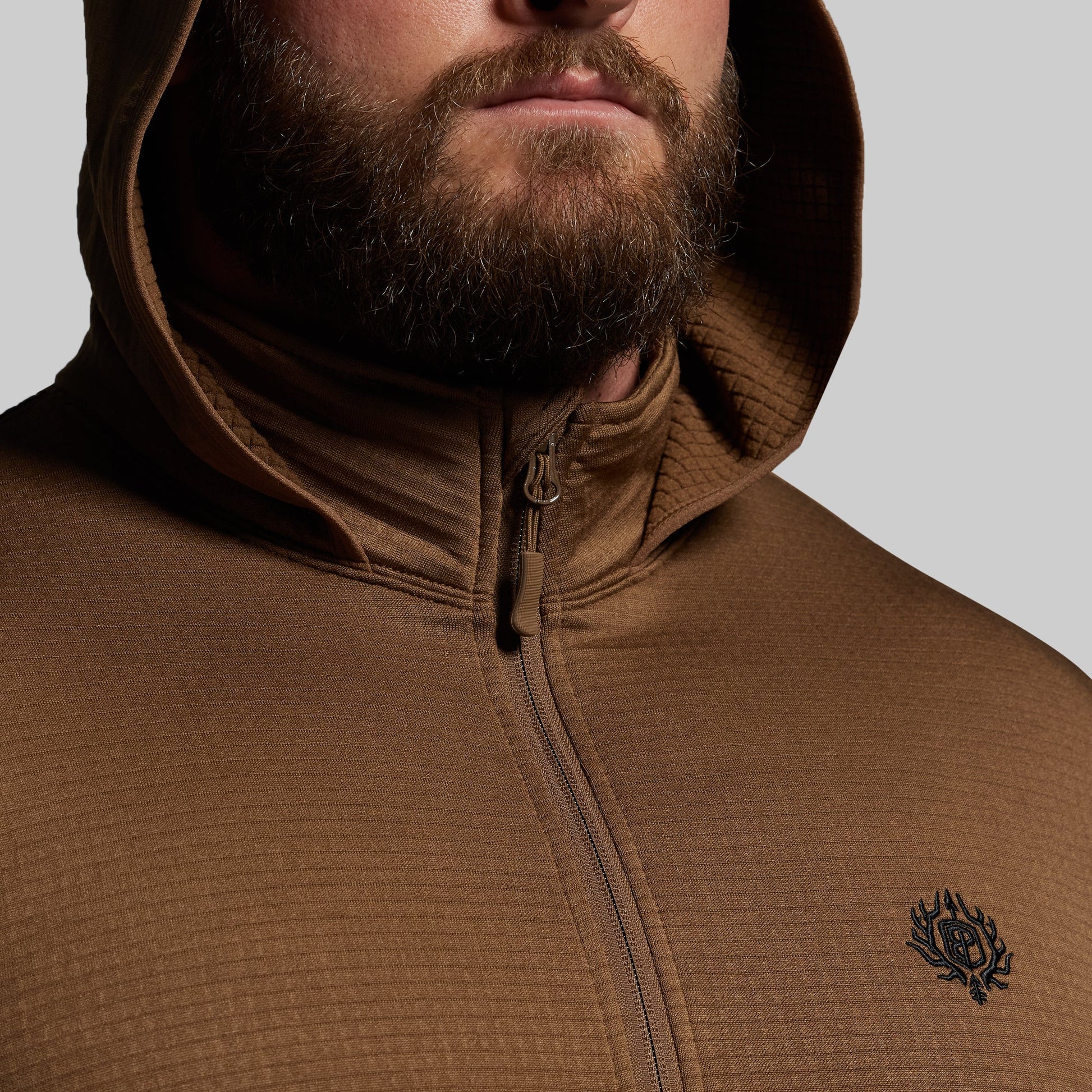 Brown hoodie with a logo on a gray background